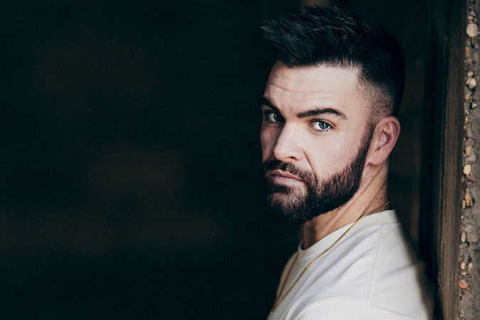 Dylan Scott leaning against a wall