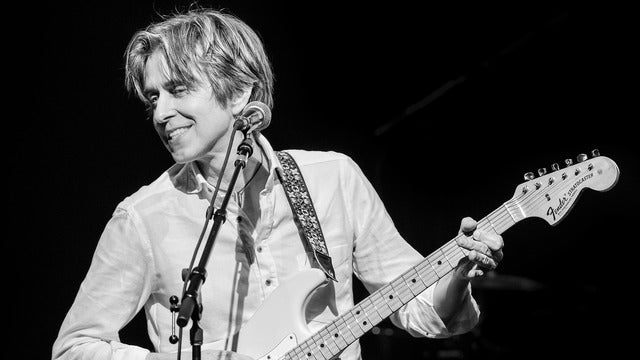 Eric Johnson at microphone with guitar