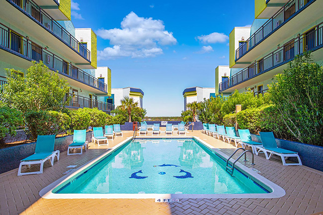 Monterey Bay Suites rooftop pool with lounge chairs and trees