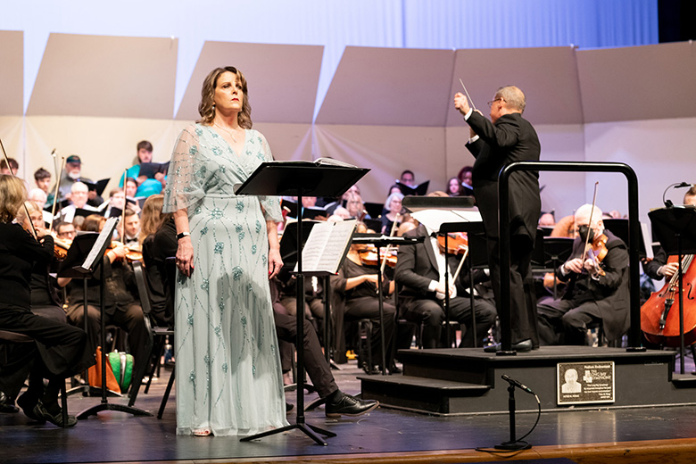 Woman singer in front of orchestra on stage