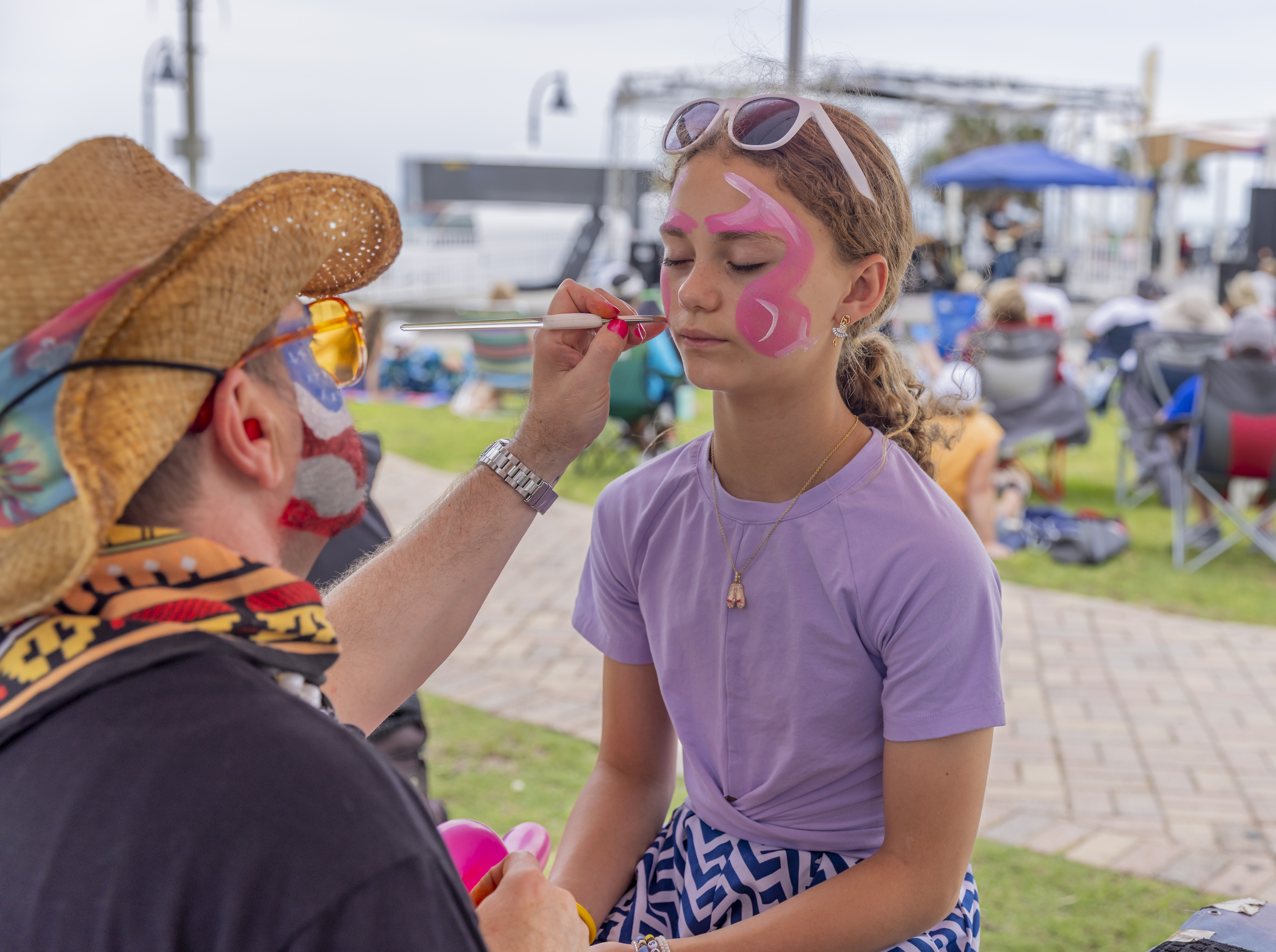 A girl gets her face painted at the Sun Fun Festival