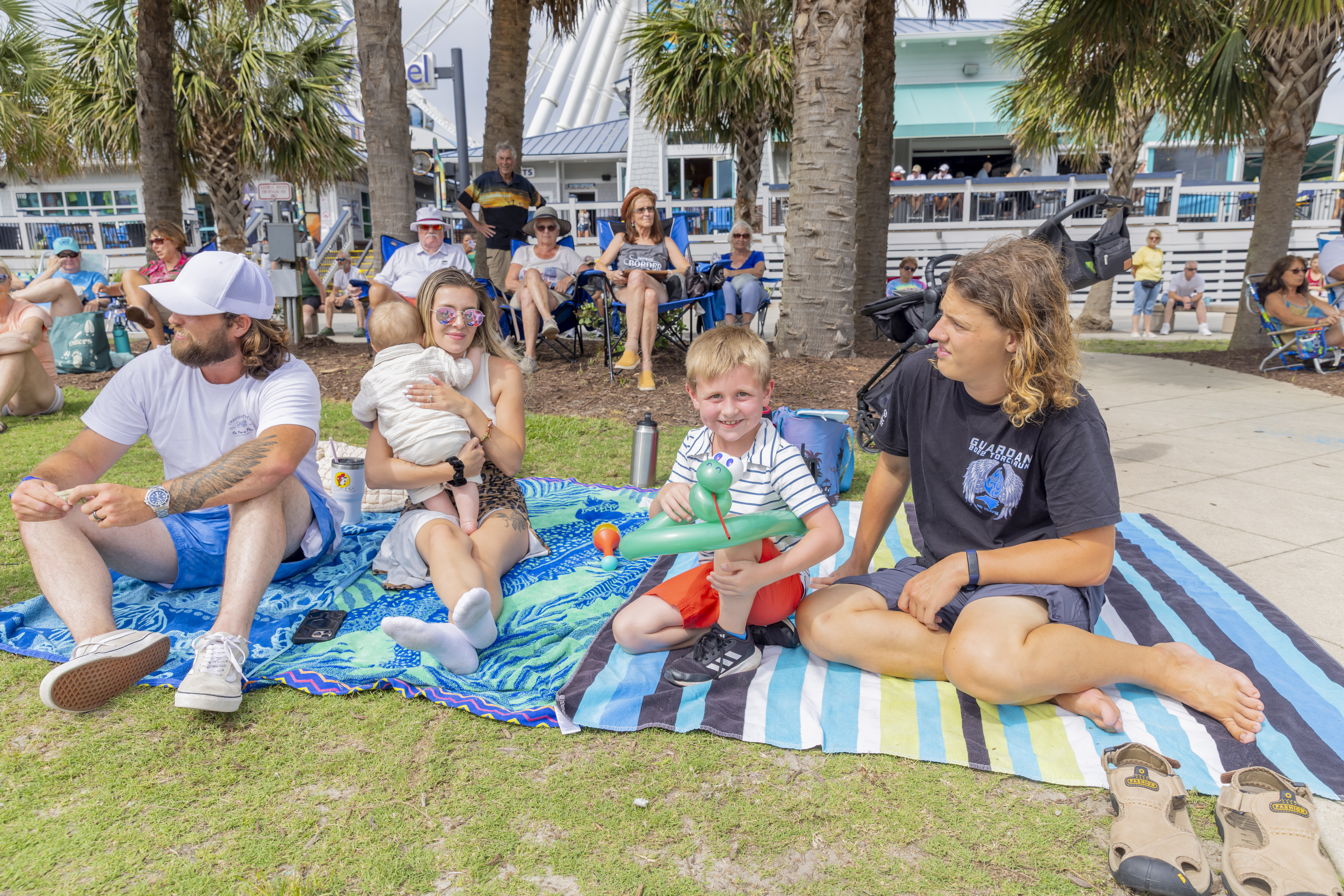 Family enjoying the live music on blankets at the Sun Fun Festival