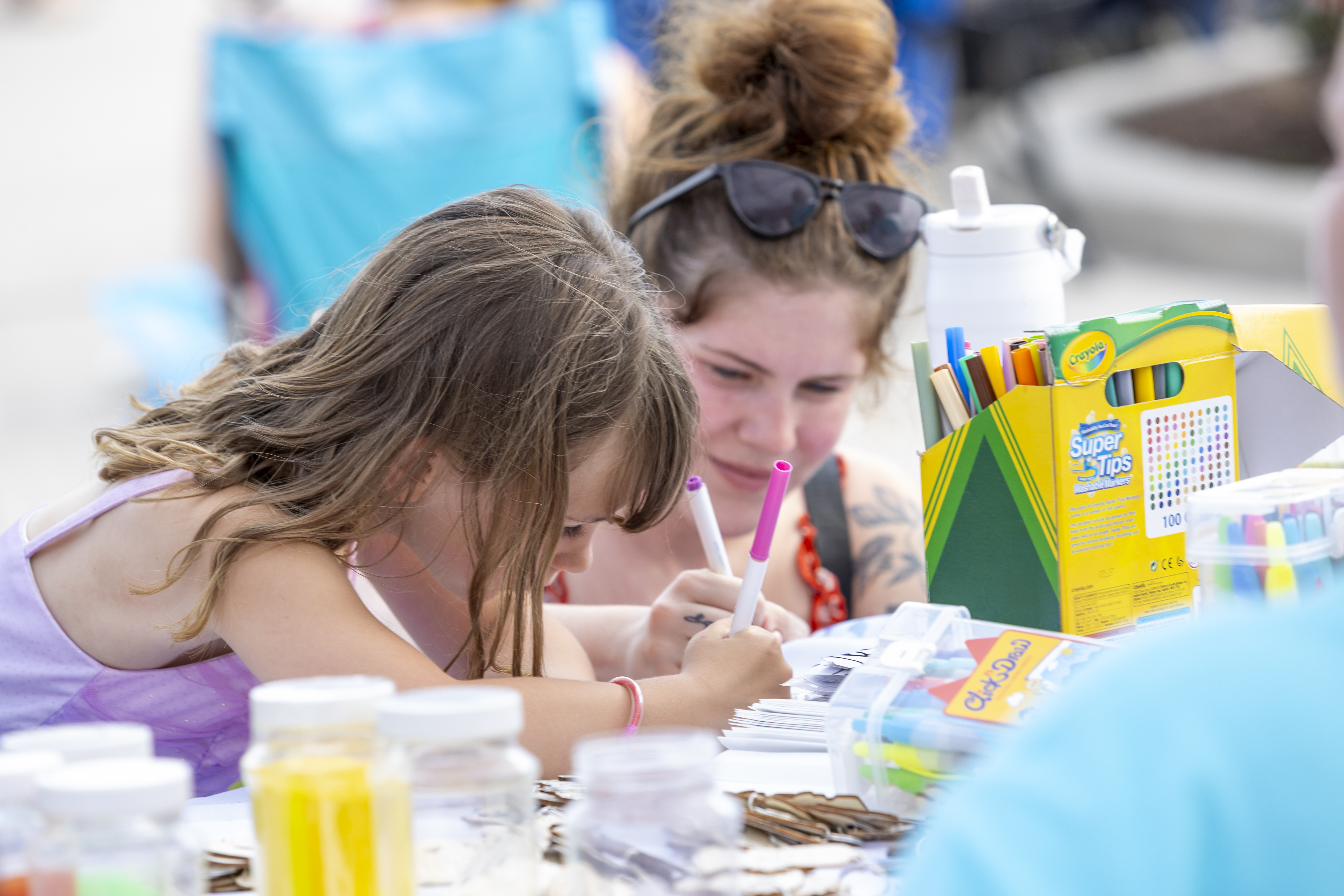 Two girls enjoy a coloring station at the Sun Fun Festival