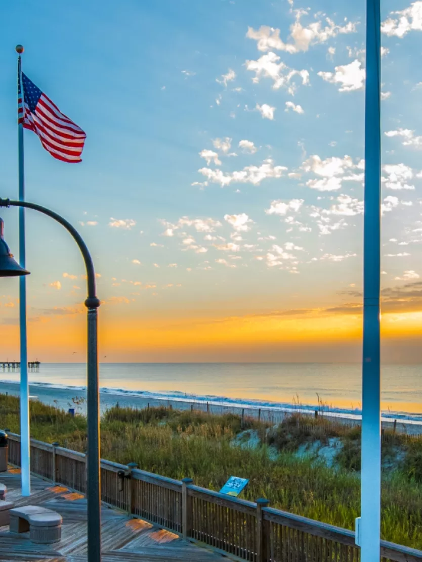 The Myrtle Beach boardwalk waking up to a yellow sunrise.