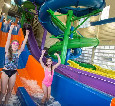 Two girls cheering at bottom of waterslides at The Breakers