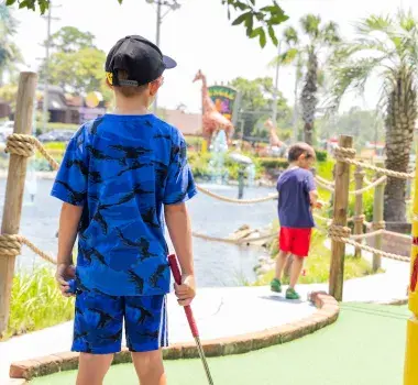 Kids playing mini golf at Jungle Safari course
