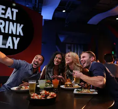Dave and Busters friends at table taking selfie
