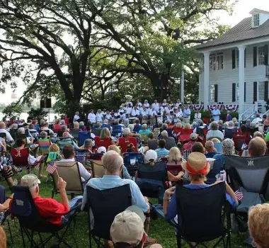 Community members gather on the lawn to listen to outdoor choir.