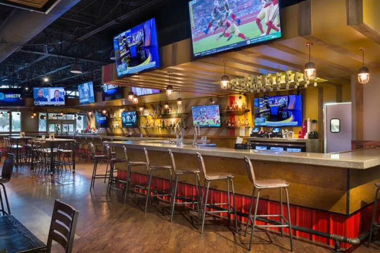 Empty bar with chairs and TVs overhead