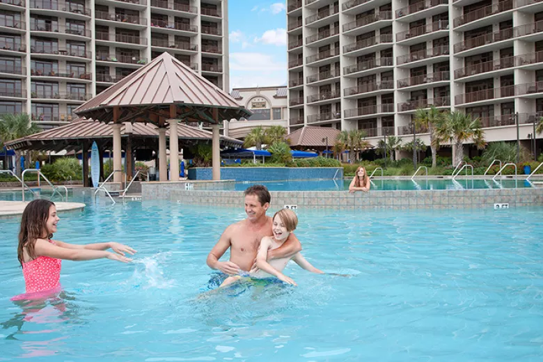 North Beach Resort father playing with kids in oceanfront pool