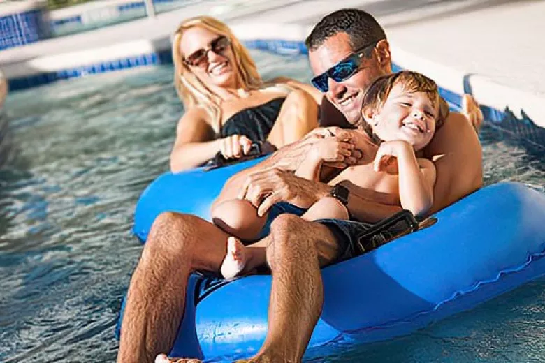 Family of three having fun riding on lazy river