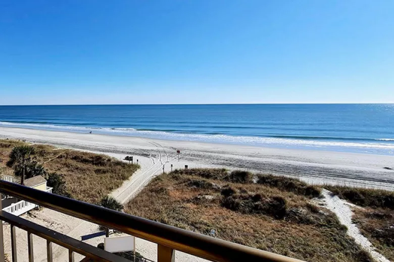 Balcony view of beach and ocean with clear blue sky
