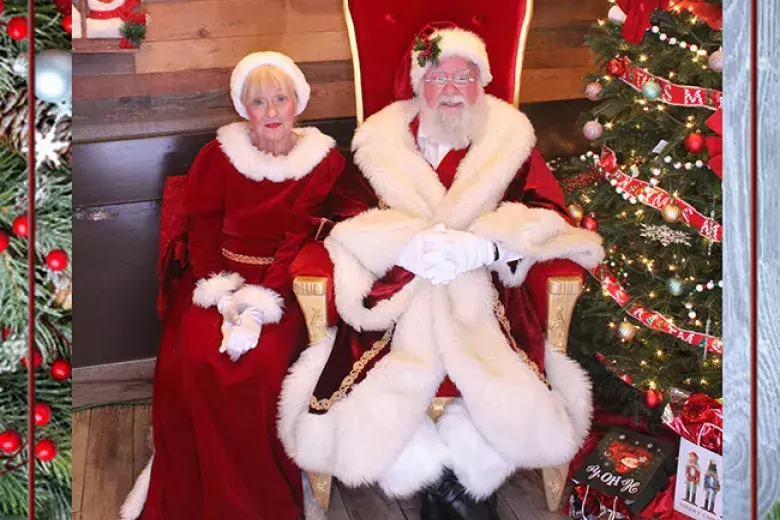 SantaFrank and Mrs. Claus sitting beside a Christmas Tree