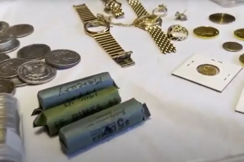 Jewelry, individual and rolled coins displayed on a table