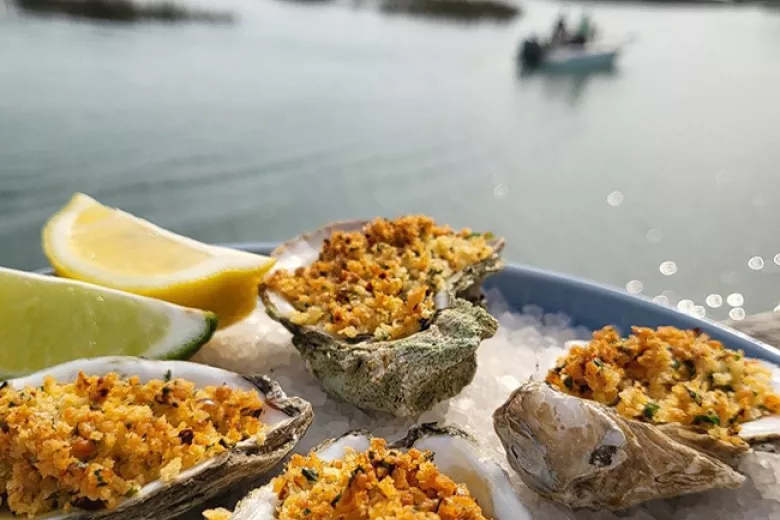 Neptune Bistro oysters with a view of inlet with boat