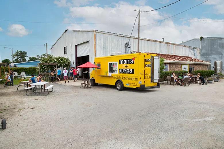 New South exterior with picnic tables and food truck