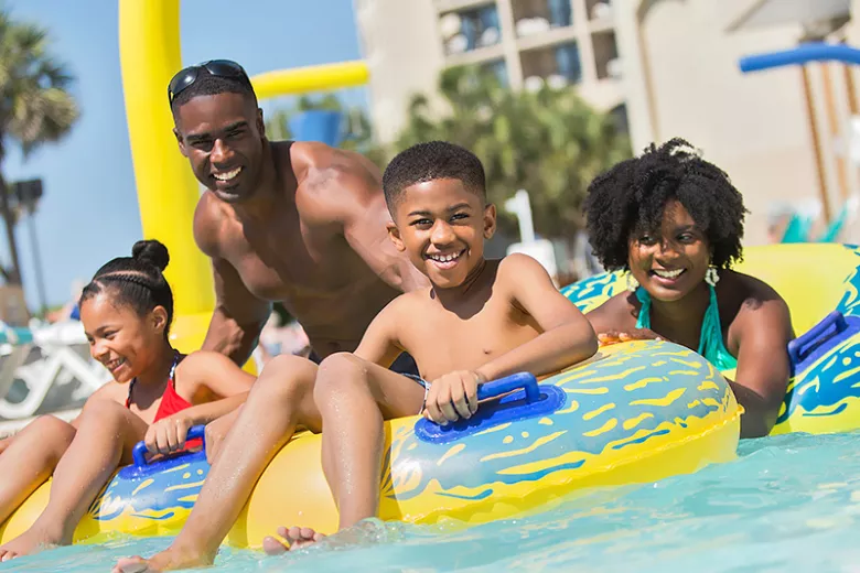 Beach Cove family of four on pool floaties