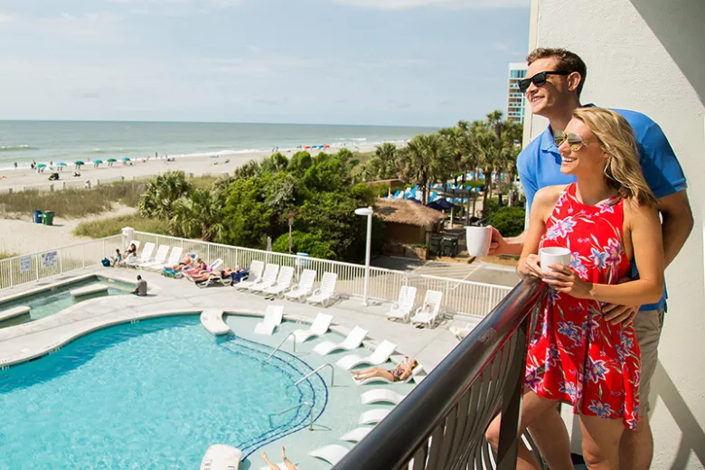 hotel BLUE couple on balcony overlooking pool and beach