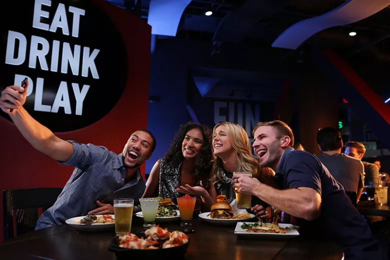 Dave and Busters friends at table taking selfie