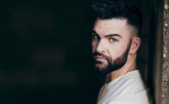Dylan Scott leaning against a wall