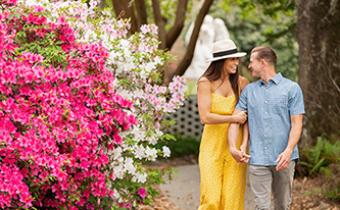 Couple walking in Brookgreen Gardens with flowers