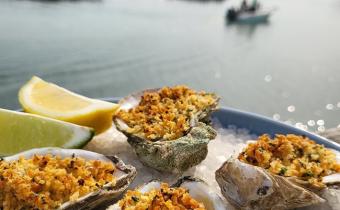 Neptune Bistro oysters with a view of inlet with boat