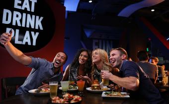 Dave and Busters friends at table taking selfie