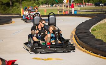Vistors racing go-karts at the Broadway Grand Prix.