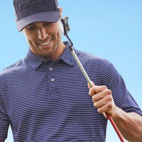 Golfer in striped shirt and ball cap holding golf club