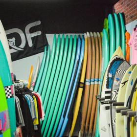 Different colored Surfboards stacked and standing on end
