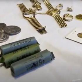 Jewelry, individual and rolled coins displayed on a table