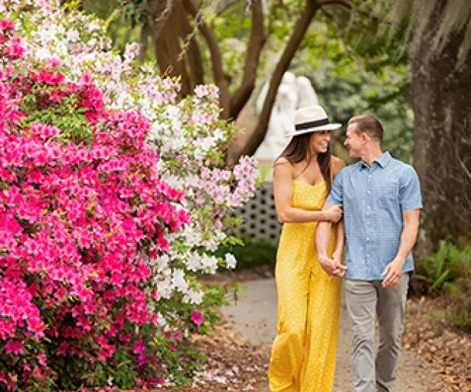 Couple walking in Brookgreen Gardens with flowers