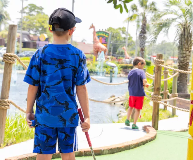 Kids playing mini golf at Jungle Safari course