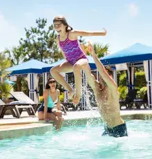 Dad tossing daughter up in the pool