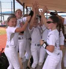 Softball players celebrating in dugout