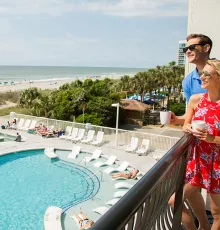 hotel BLUE couple on balcony overlooking pool and beach