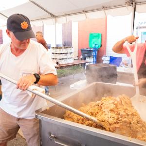 People cooking a big pot of chicken bog at Loris bog off