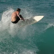 Jack's Surf Lessons surfer on ocean hitting a wave