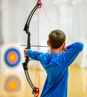 Boy shooting arrow at target