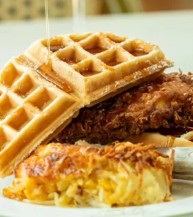Chicken and Waffles from Croissants with syrup drizzled on top