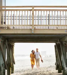 Couple walking under the pier in Myrtle Beach