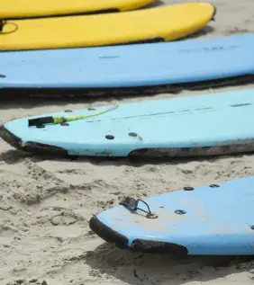 Surfboards in a line on the beach.
