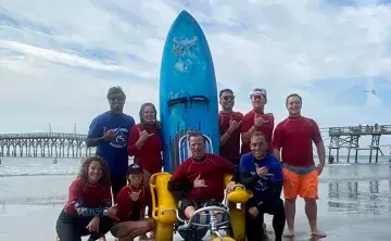 Group of surfers on the beach with surf board