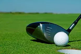 Putter on green with golf ball