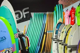 Different colored Surfboards stacked and standing on end