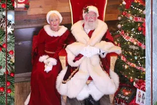 SantaFrank and Mrs. Claus sitting beside a Christmas Tree