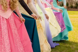 Princesses wearing gowns in various colors shown from waist down