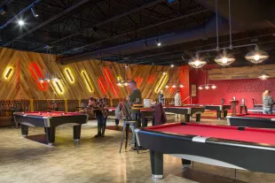 Six pool tables two people playing at two of the tables