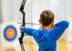 Boy shooting arrow at target