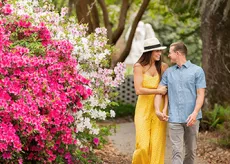 Couple walking in Brookgreen Gardens with flowers